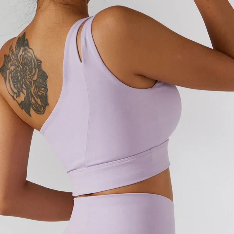 Light purple one-shoulder sports bra with tattoo, part of a piece tennis suit for women
