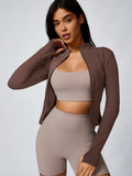 Brown cropped athletic jacket with beige sports bra and biker shorts set