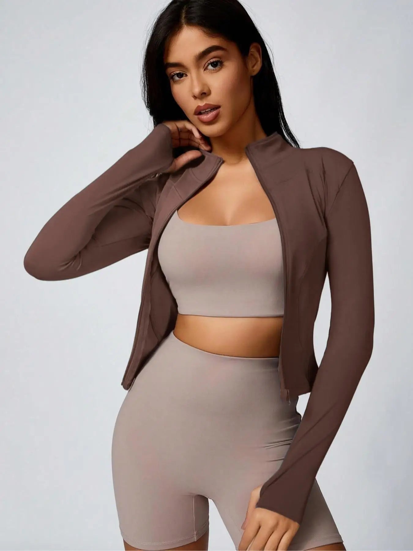 Brown cropped athletic jacket with beige sports bra and biker shorts set