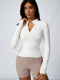 Brown cropped athletic jacket with dry breathable white long-sleeve mock neck and thumbholes