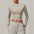 Light tan long-sleeve crop top with mock neck, ideal for sports yoga long and running fitness wear