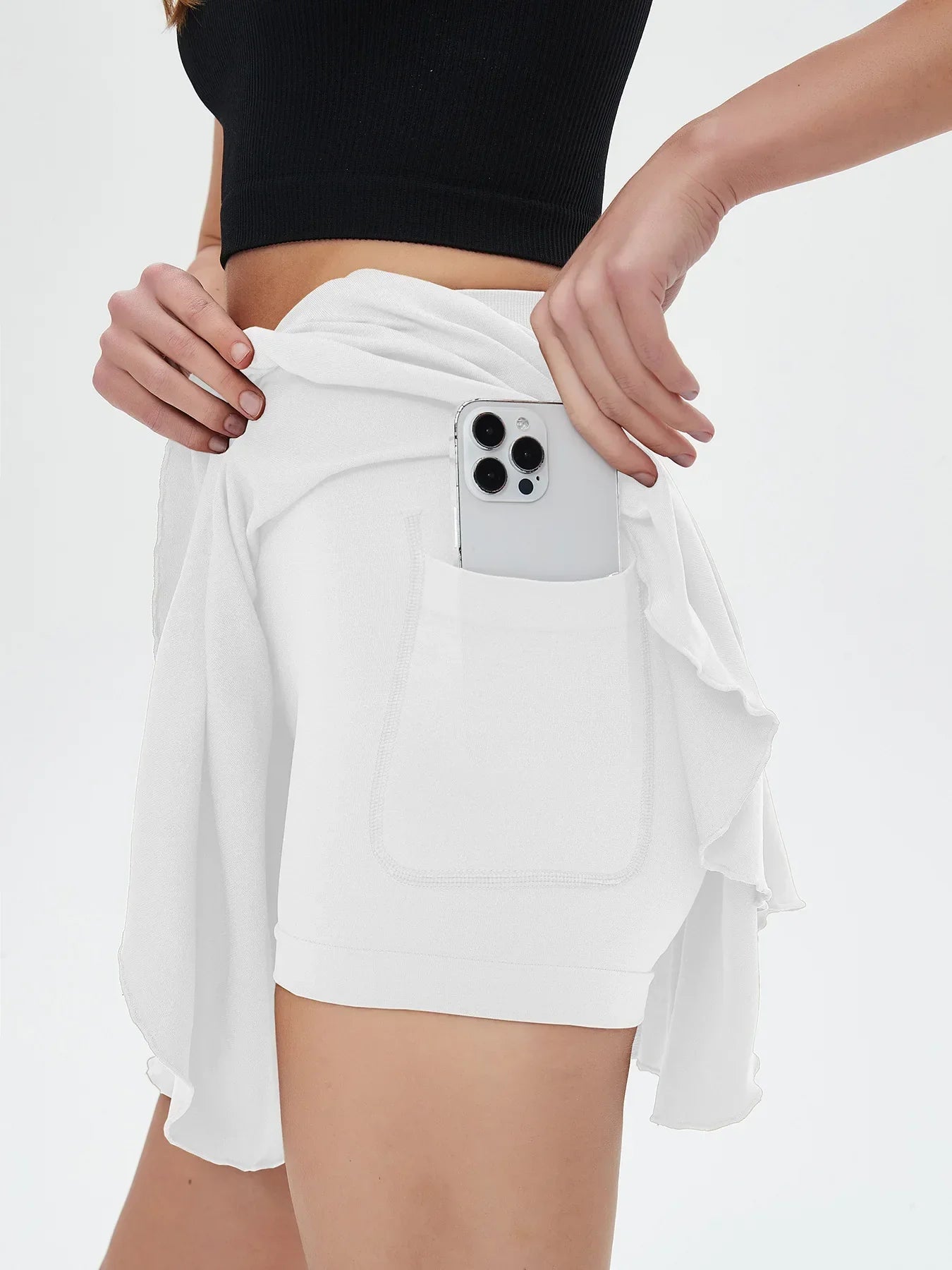 High waisted tennis mini skirt with side pocket holding smartphone