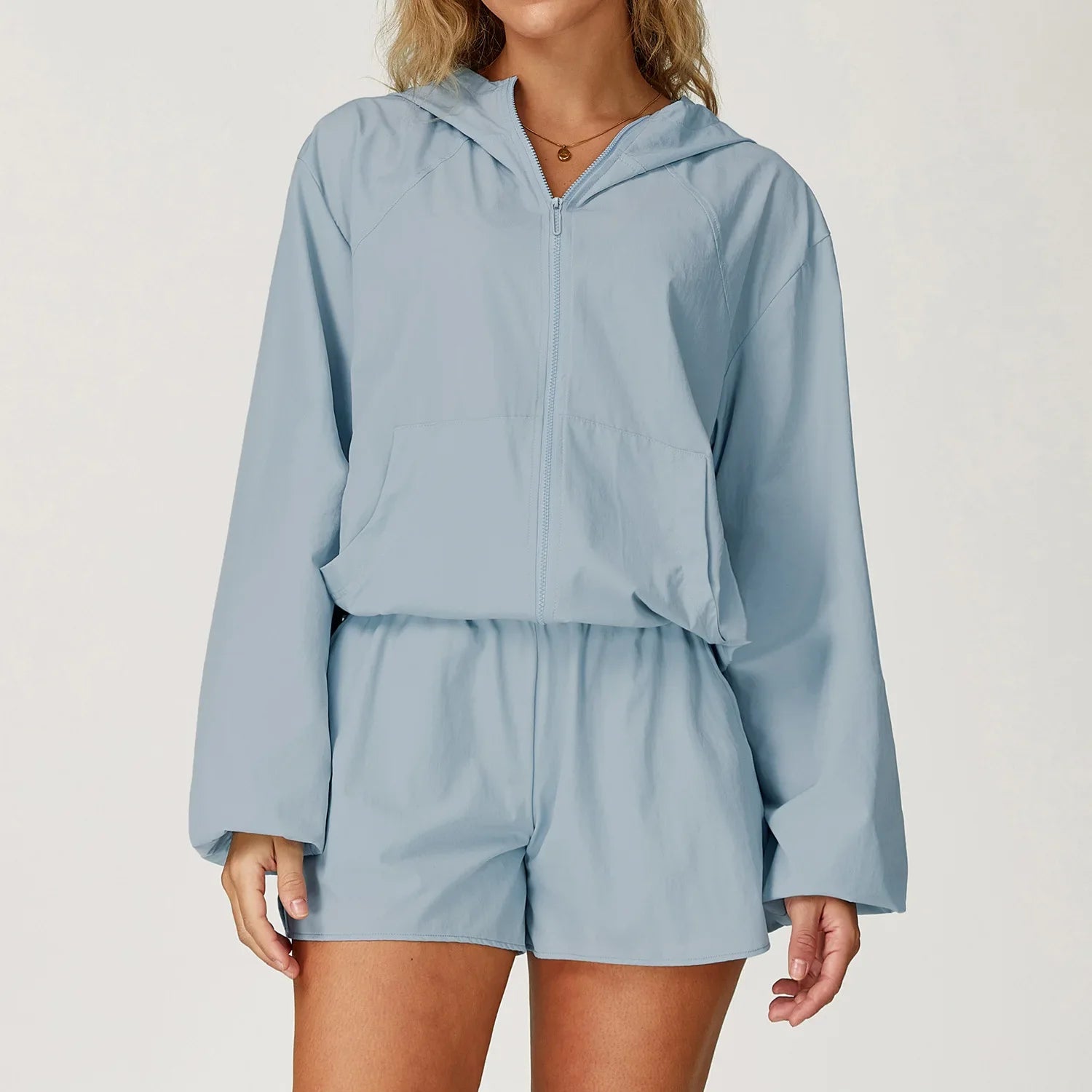 Light blue hooded windbreaker set for outdoor sports women featuring long sleeves and matching shorts
