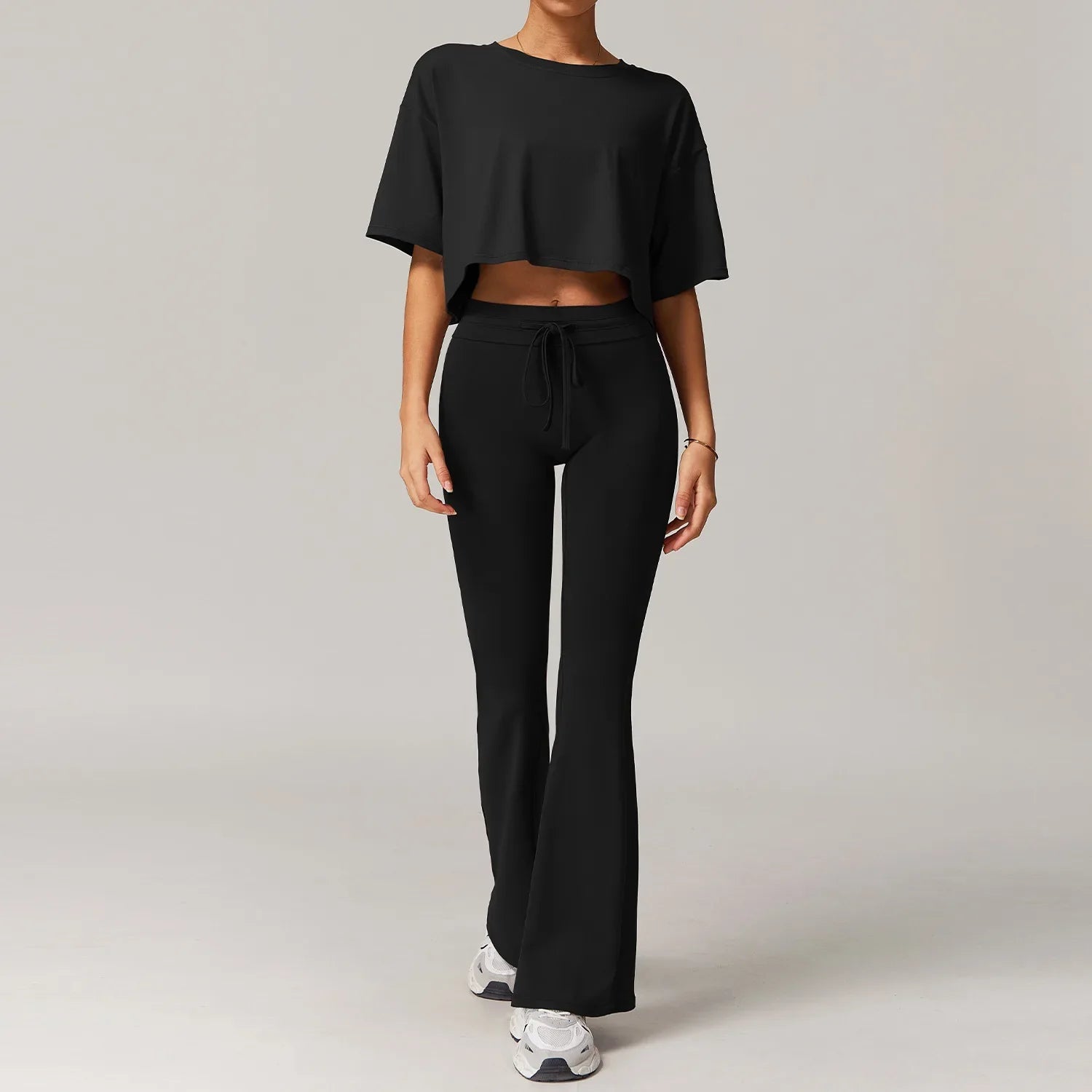 Women sportswear 2pcs set featuring black cropped t-shirt and flared sweatpants for yoga