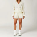 Woman in cream hooded jacket and shorts, gym lightweight windbreaker dress