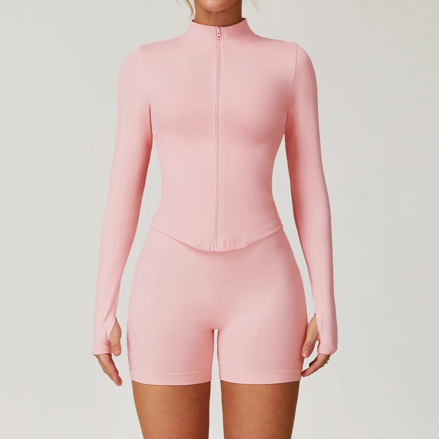 Light pink seamless gym set with long-sleeve zip-up top and biker shorts